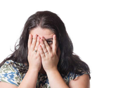 Young woman covering her face isolated on white background.の写真素材