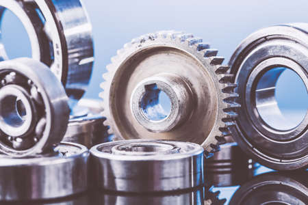 Group of various ball bearings and gears close up on nice blue background with reflections. Toned.の写真素材