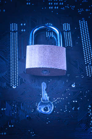 Padlock with a key on computer motherboard. Internet data privacy information security concept. Blue toned imageの写真素材