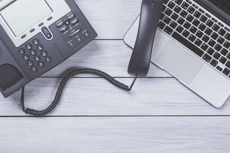 Business work place with modern phone and laptop on wooden table. Top view and copy spaceの写真素材