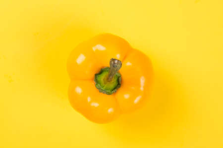 Top view of bright yellow bell pepper paprika on yellow backgroundの写真素材