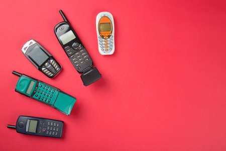 Old vintage mobile phones on red background.の写真素材