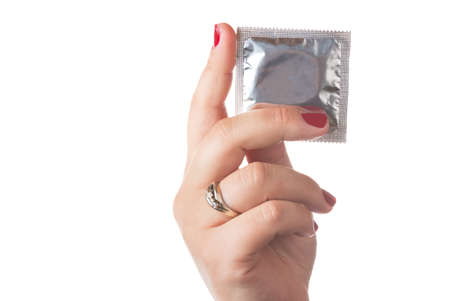 Condom in female hand with red nails. Isolated on white backgroundの写真素材