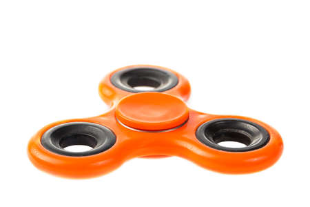 Orange fidget spinner close up, stress relieving toy isolated on white backgroundの写真素材