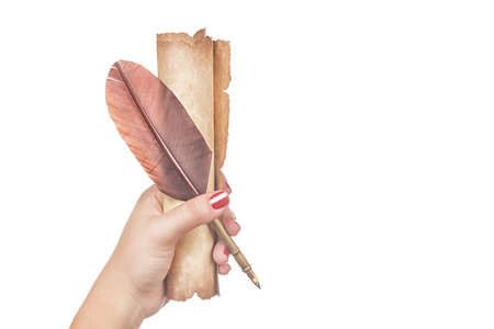 Literature concept. Female woman hand holds a feather quill pen with old vintage scroll isolated on...