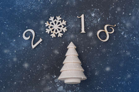 Happy New Year 2018 of real wooden figures with a fir tree on black background with snowの写真素材