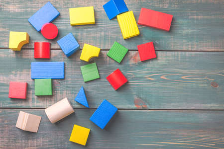 Geometric shapes for kids logical thinking. Colorful wooden blocks on green wooden background. Children's building blocksの写真素材