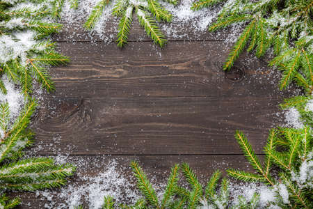 Christmas fir tree on a dark wooden board with snow. Christmas or new year frame for your project with copy spaceの写真素材