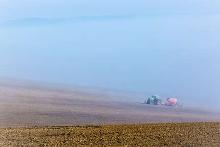 Beautiful misty foggy autumn landscape with working tractor in south moravia, Czech Republic. Agriculture conceptの写真素材