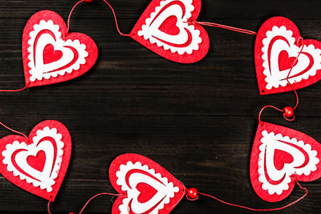 Valentines Day concept. Dark wooden background for design to Valentine's Day project. Decorative red and white hearts frame. Top viewの写真素材