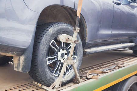 Tow truck towing a car. Car wheel close up with selective focus. Parking penalty charge concept