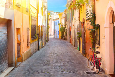 Narrow street of the village of fishermen San Guiliano with colorful houses and a bicycle in early...