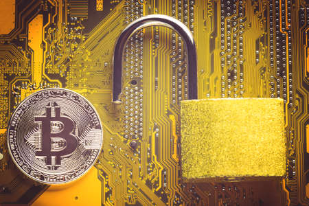 Bitcoin cryptocurrency with opened, padlock on computer motherboard. Crypto currency - electronic...