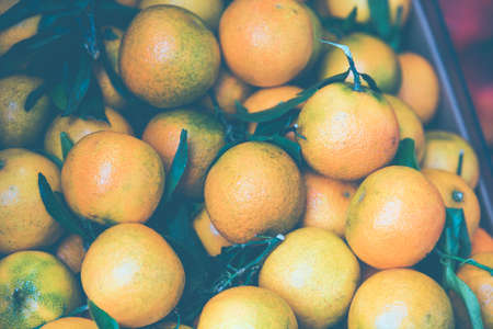 Orange tangerines mandarin in a box ourdoors market. Toned imageの写真素材