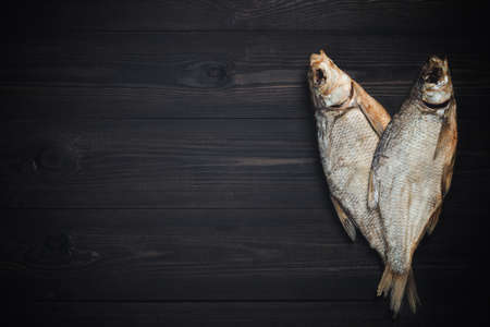 Dried fish breams on dark wooden table with copy space. Beer snack in Russiaの写真素材