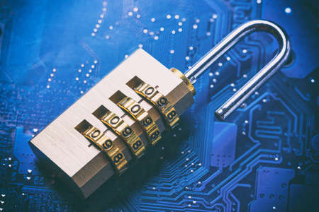 Opened padlock on computer motherboard. Internet data privacy information security concept. Blue toned image.の写真素材