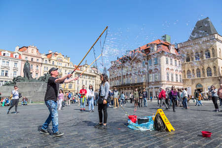 Prague, Czech Republic - April, 2018: Local man entertaining tourists and citizens with big soap bubbles in the city center of Prague Staromestska Namesti near Tyn Church. Street showのeditorial素材