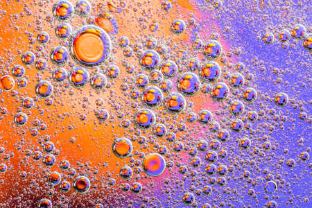 Macro shot of oil bubbles with water on colorful background. Space and universe planets styled abstract image.の写真素材
