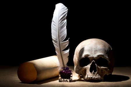 Drama or theater concept. Old inkstand with feather near scroll with skull against black background....
