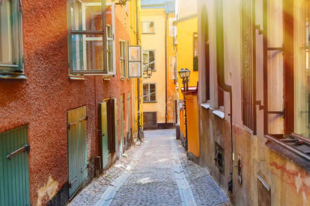 The narrow cobblestone street with a bicycle and medieval houses of Gamla Stan historic old center of Stockholm at summer sunny dayの写真素材