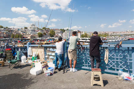 Istanbul, Turkey - August, 2018: Fishermen on Galata Bridge in Istanbul, Turkey during summer sunny day. Galata Bridge is a bridge that crosses the Golden Horn in Istanbulのeditorial素材