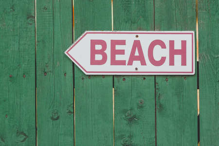 Beach access sign on rustic green wooden fenceの写真素材