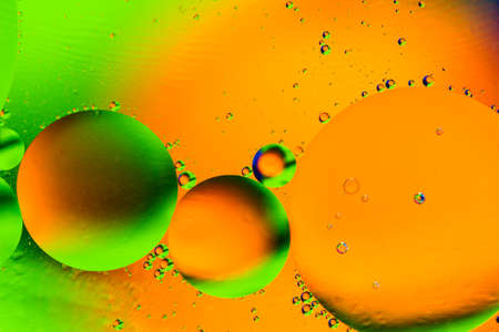 Abstract colorful background with oil drops and reflections on water surface. Cosmic orange and green abstract image.の写真素材