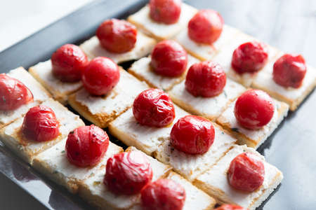 Little sandwiches with cheese and grilled cherry tomato. Catering food