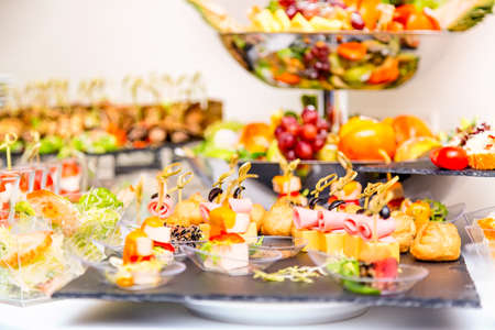 Beautifully decorated catering banquet table with different food snacks and fruits.の写真素材