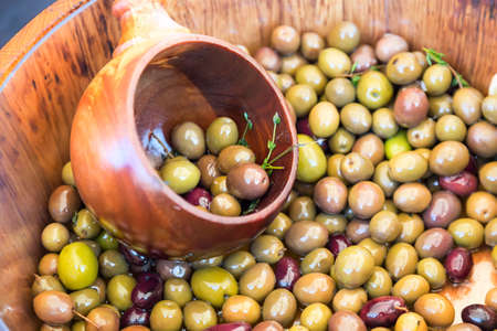Marinated green olives in wooden spoon and barrel. Close up image.の写真素材