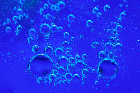 Bubbles of oxygen under water. Blue toned water structure. Selective focus
