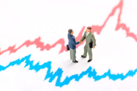 Business investment and finance concept. Miniature people figurines businessmen stand on finance graphの写真素材