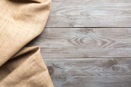 Burlap hessian sacking cloth on wooden table background with free spaceの写真素材