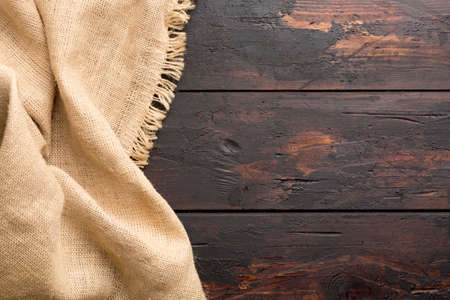 Burlap hessian sacking cloth on wooden table background with free spaceの写真素材