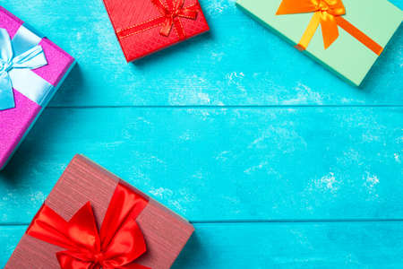 Colorful gift boxes with ribbons on nice blue wooden background. Copy space. Christmas or birthday...