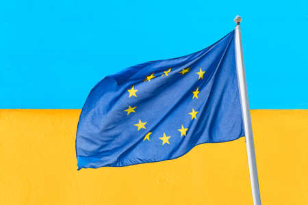 Ukraine and European Union. Waving European Union flag against blue yellow wall ukrainian flag. Ukraine goes to Europe conceptの写真素材