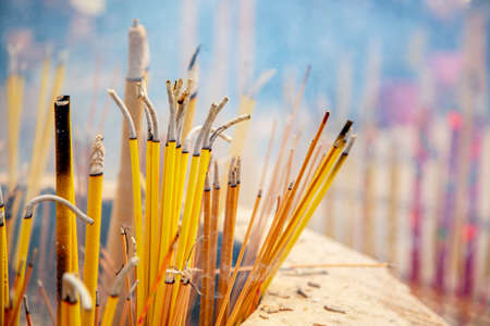 Closeup view of burning and smoking incense sticks at the Buddhist Po Lin Monastery in Hong Kong...