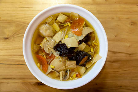 Chinese cousine. Chinese soup in a plate on wooden table. Top viewの写真素材