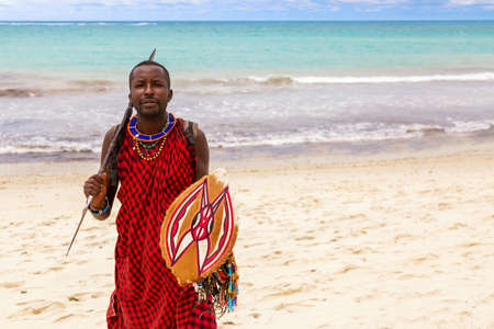 Diani Beach, Ukunda, Kenya - August, 2019: African Maasai warrior with spear and shield at the Diani beachのeditorial素材