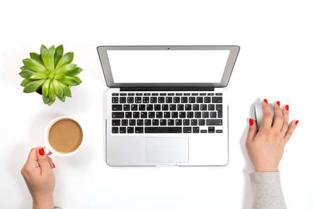 Top view of office desk table. Woman with red nails holding cup of coffee and working on modern...