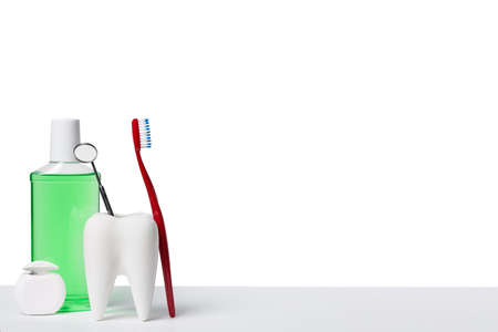 Dental health and teethcare concept. Dental mirror in white tooth model near mouthwash, toothbrush...