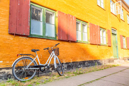 Picturesque of Copenhagen. Old yellow house of Nyboder district with bike. Old Medieval district in Copenhagen, Denmark.の写真素材