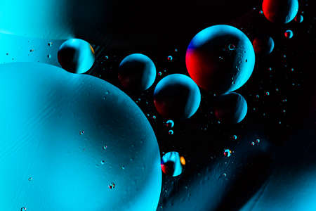 Macro shot of oil bubbles with water on colorful background. Space and universe planets styled psychedelic abstract image.の写真素材