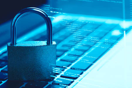 Padlock on laptop with a programming code language. Internet data privacy information security...