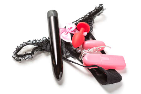 Female satisfaction concept. Anal plug, vibrator egg and black dildo on female panties isolated on white background. Sex toys for adults.の写真素材