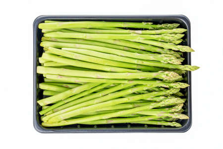 Fresh raw sprouts of green asparagus in a box isolated on white background. Close up.の写真素材