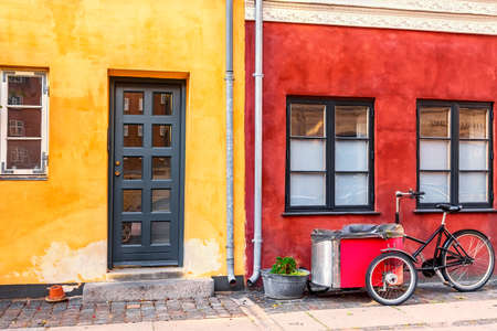 Old red and yellow houses in the center of Copenhagen with typical bicycle. Old Medieval district in Copenhagen, Denmark.の写真素材