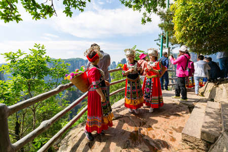 Zhangjiajie, Wulingyuan, China - May, 2019: Beautiful women in Chinese red national dress posing against natural landscape with stone pillars quartz mountains.のeditorial素材
