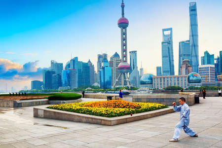 Shanghai, China - May, 2019: Man making exercise training against Shanghai pudong skyline business district in the morningのeditorial素材