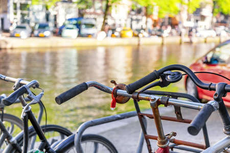 Bicycles parking lot in Amsterdam, Netherlands against a canal during summer sunny day. Amsterdam postcard iconic view. Tourism conceptの写真素材